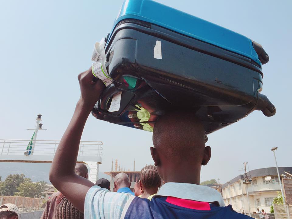 荷物を頭で運ぶシエラレオネの男性