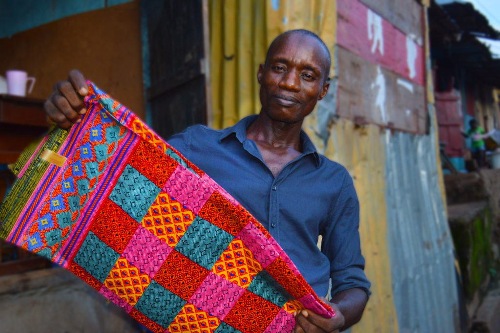 布を持ち微笑むシエラレオネ男性