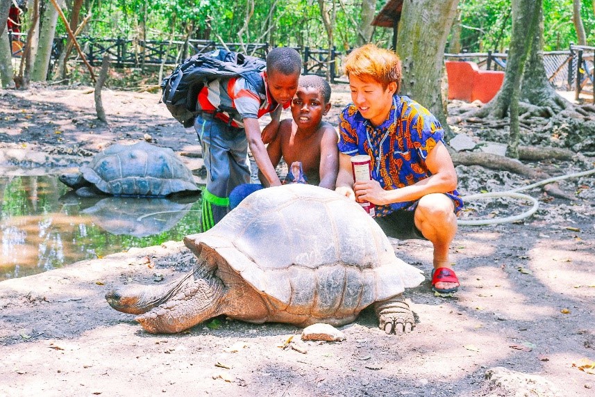 小河さんと亀に触る子供